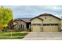 House exterior with a two car garage and stone accents at 4640 Belford Cir, Broomfield, CO 80023