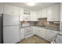 White kitchen with granite countertops, featuring a microwave, oven, and dishwasher at 3465 S Poplar St # 308, Denver, CO 80224