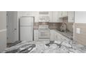 Kitchen with white cabinets, granite countertops, and stainless steel appliances at 3465 S Poplar St # 308, Denver, CO 80224