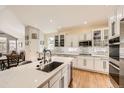 Bright kitchen features white cabinets, quartz countertops, and stainless steel appliances at 7360 S Owens Ct, Littleton, CO 80127