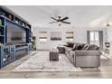 Spacious living room featuring a large sectional sofa, built-in shelving, and a fireplace at 7652 Pennsylvania Ct, Denver, CO 80229