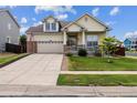 Two-story house with a brick and beige exterior, landscaped lawn, and a two-car garage at 4293 Clover Ln, Brighton, CO 80601