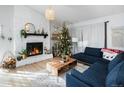 Bright living room with a stone fireplace, sectional sofa, and large windows at 29116 Pine Rd, Evergreen, CO 80439