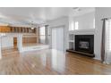 Spacious living room, hardwood floors, fireplace, and kitchen view at 19877 E 40Th Ave, Denver, CO 80249