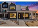 Modern home with dark brick exterior, covered porch, and rooftop deck at 888 S Valentia St # 106, Denver, CO 80247