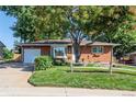 Brick ranch home with a landscaped lawn and a white garage door at 3661 W Greenwood Pl, Denver, CO 80236