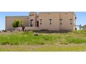 Tan stucco home with a large yard and beautiful landscaping at 6001 S County Road 161, Strasburg, CO 80136