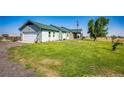 Ranch style home with attached garage and expansive green lawn at 6751 S County Road 129, Bennett, CO 80102