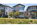 Two-story home with gray and brick exterior, green door, and landscaping at 6015 N Orleans St, Aurora, CO 80019