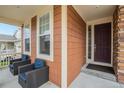 Front porch with two wicker chairs and a door at 20052 W 95Th Pl, Arvada, CO 80007