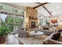 Open living room with stone fireplace and hardwood floors at 1210 Wildcat Bend Ct, Castle Rock, CO 80108