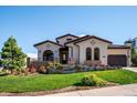 Elegant two-story home with stucco and stone accents, beautifully landscaped grounds at 7912 Galileo Way, Littleton, CO 80125
