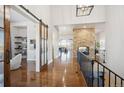 Bright and spacious hallway with a barn door, hardwood floors and a brick fireplace at 7912 Galileo Way, Littleton, CO 80125