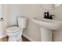 Small bathroom with pedestal sink, toilet, and shower at 3202 Boral Owl Dr, Brighton, CO 80601