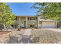 Brick ranch home with walkway, landscaping, and attached garage at 348 S Tucson Way, Aurora, CO 80012