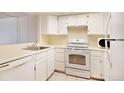 Kitchen equipped with essential appliances, white cabinetry, and ample counter space at 1915 S Balsam St, Lakewood, CO 80227