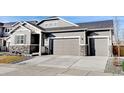 Gray two-story house with two-car garage, stone accents, and landscaped yard at 61 Western Sky Cir, Longmont, CO 80501