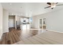 Open concept living room and kitchen with modern finishes and a sliding door to the patio at 3036 Oxley St, Strasburg, CO 80136