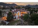 Evening view of a luxurious home with mountain backdrop, showing its backyard at 7944 Dante Dr, Littleton, CO 80125