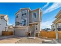 Two-story home with gray siding, attached garage, and a modern design at 16172 E 111Th Dr, Commerce City, CO 80022