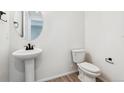 Small powder room with pedestal sink and toilet at 3218 Boral Owl Dr, Brighton, CO 80601