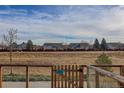 View of a grassy backyard with a fence and neighboring homes at 10334 Milwaukee Cir, Denver, CO 80229