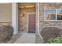 Front entry of townhome with stone accents and a brown door at 8200 E 8Th Ave # 7103, Denver, CO 80230