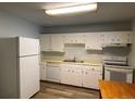 Kitchen features white cabinets, dishwasher, and an electric stove at 2565 S Sheridan Blvd # 20, Denver, CO 80227
