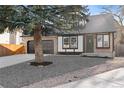 Two-story house with dark gray garage doors and a stone front yard at 13750 W 65Th Ave, Arvada, CO 80004