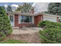 Brick front of the house with a small patio and landscaping at 2775 S Eaton Way, Denver, CO 80227