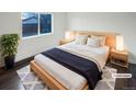 Bright bedroom with a light wood platform bed and window view at 4635 Sable St, Denver, CO 80239