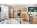 Modern kitchen featuring stainless steel appliances and light wood cabinets at 7862 S Kalispell Cir, Englewood, CO 80112