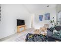 Living room with vaulted ceiling, comfy seating, and a large TV at 20123 E Ithaca Pl, Aurora, CO 80013