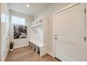 Bright entryway with built-in bench, coat hooks, and white door at 21541 E 60 Th Ave, Aurora, CO 80019