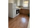 Cozy kitchen with wood-look flooring, white appliances, and wood cabinets at 420 E 45Th Ave, Denver, CO 80216