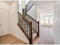 Modern staircase with dark wood railing and light wood floors at 1821 Water Birch Way, Castle Rock, CO 80108