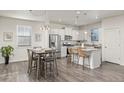 Modern kitchen with white cabinets, granite countertops, and stainless steel appliances at 109 Racer St, Bennett, CO 80102