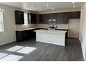 Modern kitchen with dark cabinets, island, and quartz countertops at 16654 W 93Rd Way, Arvada, CO 80007