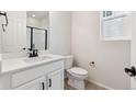 Clean bathroom with white vanity, a toilet, and a shower at 827 Goodrich Peak St, Erie, CO 80516