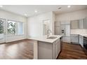 Modern kitchen with island, stainless steel appliances, and hardwood floors at 487 Interlocken Blvd # 102, Broomfield, CO 80021
