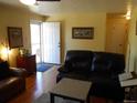 Living room with hardwood floors, leather sofas and access to front door at 12484 E Alaska Ave, Aurora, CO 80012