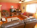 Bright living room with hardwood floors, leather furniture, and large window at 12484 E Alaska Ave, Aurora, CO 80012