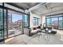 Spacious living room with large windows, city views, and access to balcony at 1401 Wewatta St # 307, Denver, CO 80202