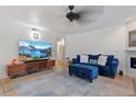 Living room with blue sofa, large TV, and access to other rooms at 5765 W Atlantic Pl # 104, Lakewood, CO 80227