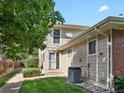 Tan two-story building exterior with private entrance and landscaping at 1250 S Monaco Pkwy # 2, Denver, CO 80224