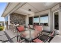 Covered deck with stone feature wall, seating area, and mountain views at 9600 Yucca Ct, Arvada, CO 80007