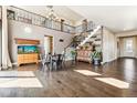 Spacious living room with hardwood floors, high ceilings, and a staircase at 8551 Orchard Way, Arvada, CO 80007