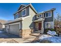 Two-story house with gray siding, three-car garage, and a partially snow-covered driveway at 1494 Ebony Dr, Castle Rock, CO 80104