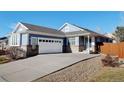 Ranch style home with two-car garage and landscaped front yard at 15827 E 107Th Way, Commerce City, CO 80022