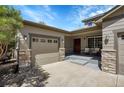 Attached garage with stone accents and a covered entryway at 1814 Primrose Pl, Erie, CO 80516